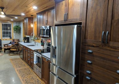 Kitchen with dark wood cabinets, and a silver refrigerator.