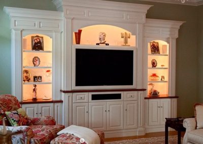 White entertainment center with white cabinets and shelves.