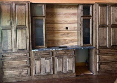 Rustic entertainment center with cabinets and drawers.