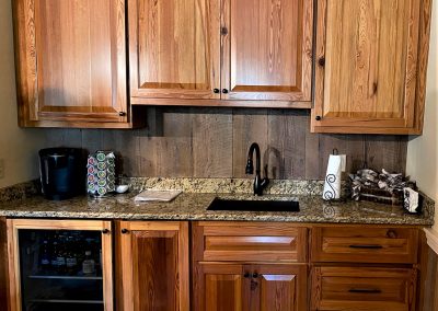Grainy sink area with cabinets and drawers.