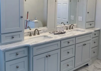 Vanity with twin sinks, light blue gray paint.