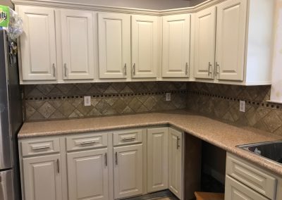 Kitchen with cream cabinets and stone countertops.